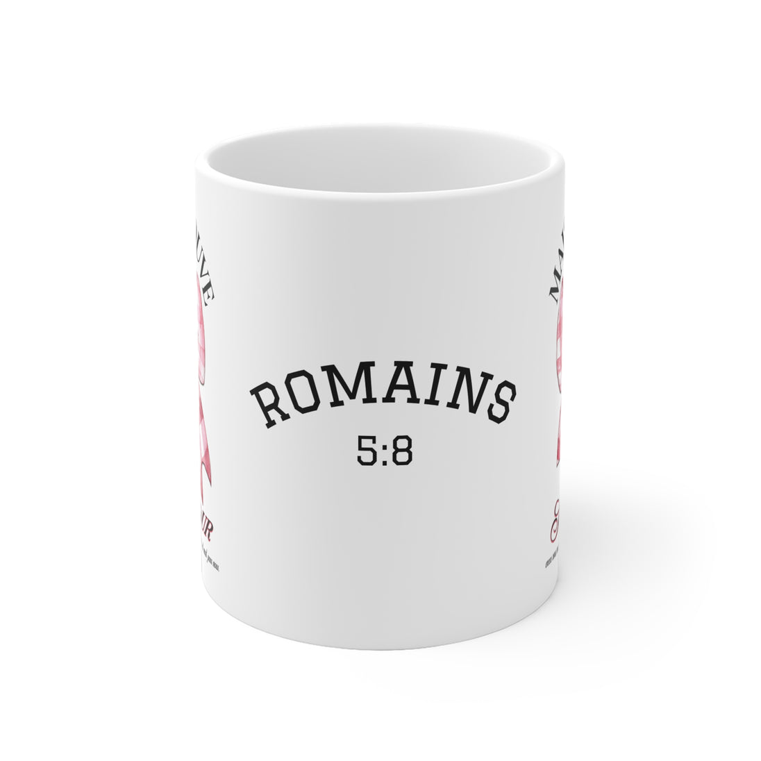 Mug blanc en céramique affichant le texte Romains 5:8 avec un motif de ruban rose.