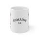 Mug blanc en céramique affichant le texte Romains 5:8 avec un motif de ruban rose.