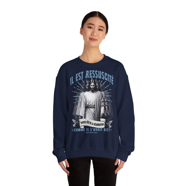 Une femme porte un sweat-shirt bleu marine avec une illustration religieuse et le texte Il est ressuscité.