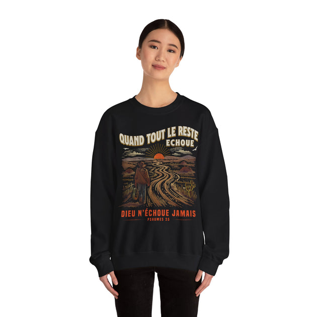 Une femme porte un sweat-shirt noir avec une illustration de paysage et un message religieux.