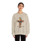 Une femme porte un sweat-shirt beige orné d'une croix florale et de l'inscription Tout est accompli.