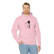 Un homme porte un sweat à capuche rose pâle avec une illustration religieuse sur la poitrine.
