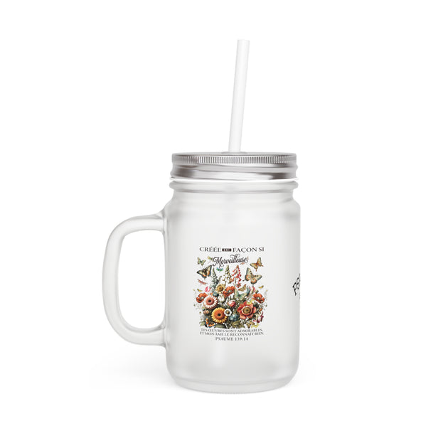 Gobelet en verre dépoli avec couvercle, paille et motif floral avec texte religieux.