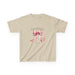 T-shirt beige pour enfant orné d'un ruban rose à l'aquarelle et d'une inscription religieuse.