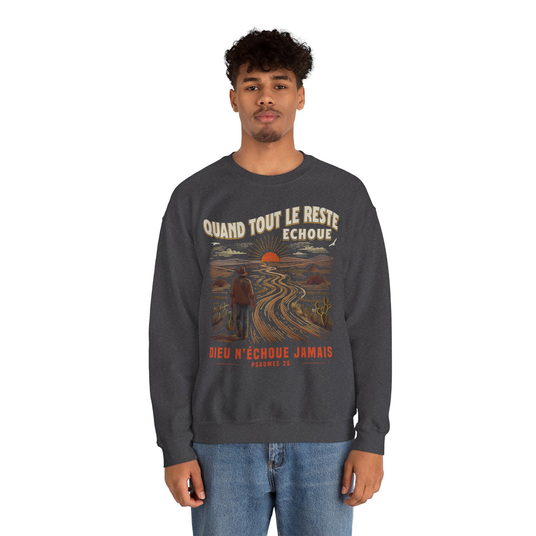Un homme porte un sweatshirt gris foncé avec une illustration de paysage et un message chrétien.