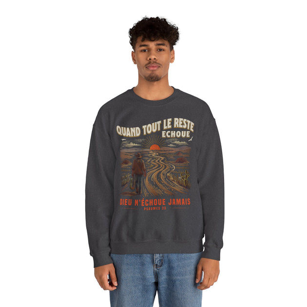 Un homme porte un sweatshirt gris foncé avec une illustration de paysage et un message chrétien.