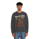 Un homme porte un sweatshirt gris foncé avec une illustration de paysage et un message chrétien.