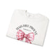 Sweat-shirt blanc plié avec un nœud rose à carreaux et l'inscription Mais Dieu prouve Romains 5:8.