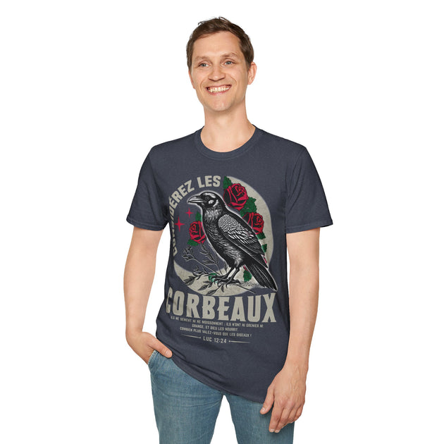 Un homme porte un t-shirt bleu marine illustré d'un corbeau, de roses et du texte Luc 12:24.