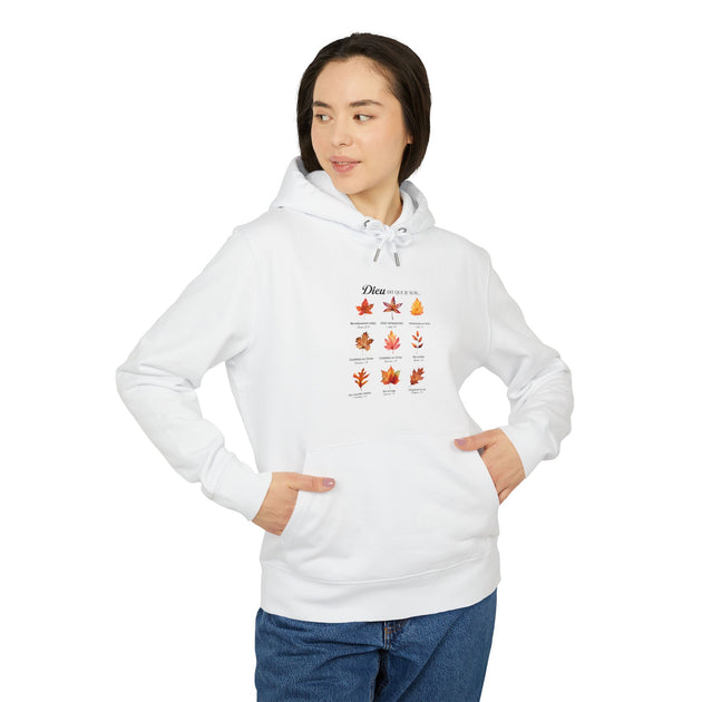 Une femme porte un sweat à capuche blanc orné d'un motif de feuilles avec des textes bibliques.
