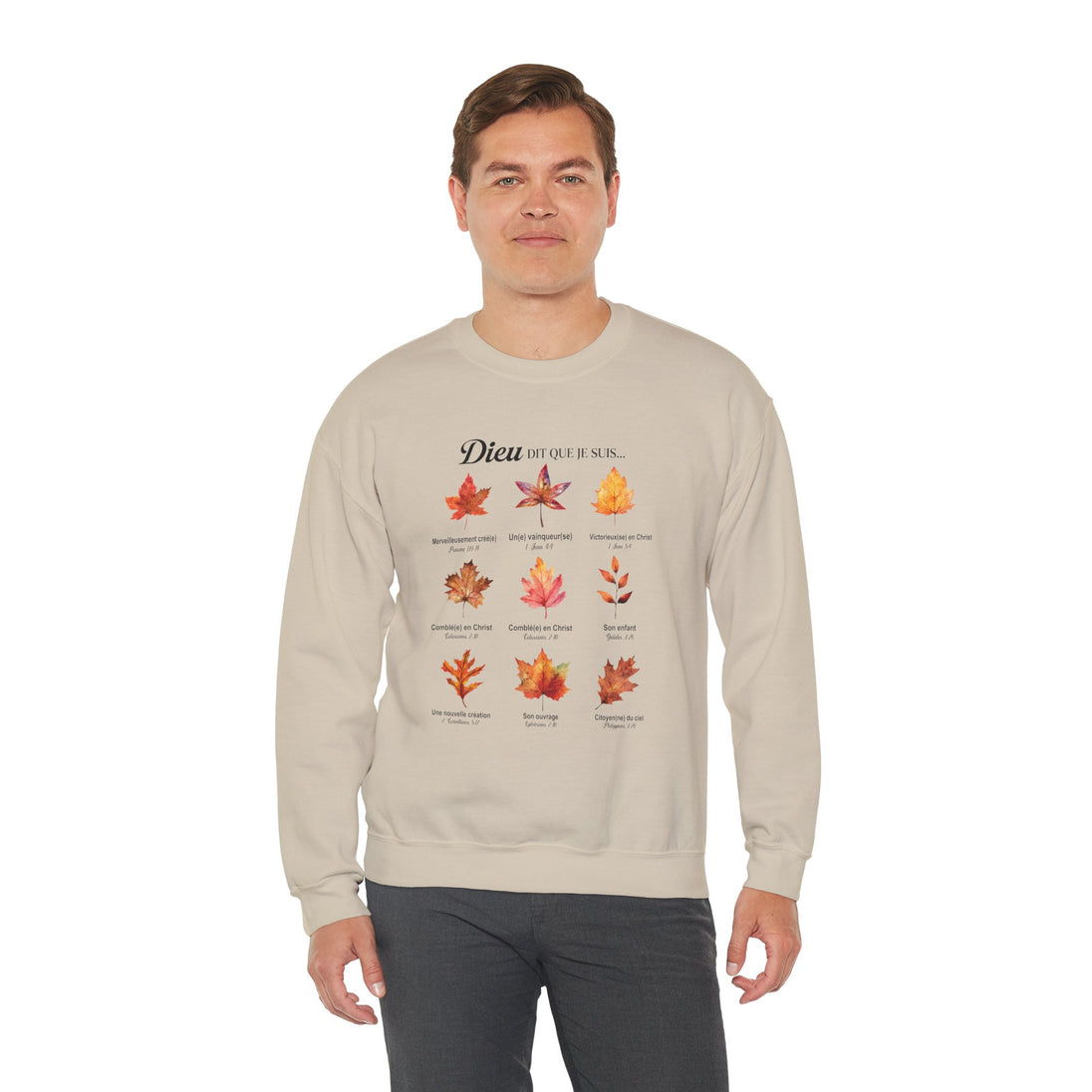 Un homme porte un sweatshirt beige orné d'un motif de feuilles et de textes bibliques en français.