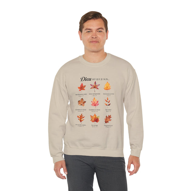 Un homme porte un sweatshirt beige orné d'un motif de feuilles et de textes bibliques en français.
