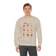 Un homme porte un sweatshirt beige orné d'un motif de feuilles et de textes bibliques en français.