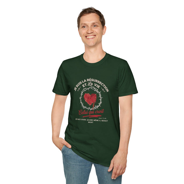 Un homme porte un t-shirt vert foncé avec un motif religieux représentant un cœur et une couronne.