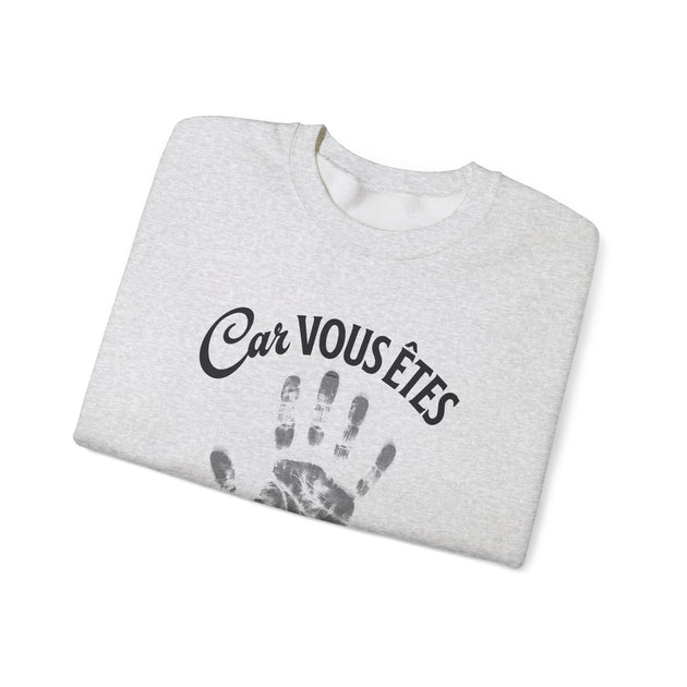 Sweat-shirt gris chiné plié avec l'inscription Car vous êtes et une empreinte de main noire.