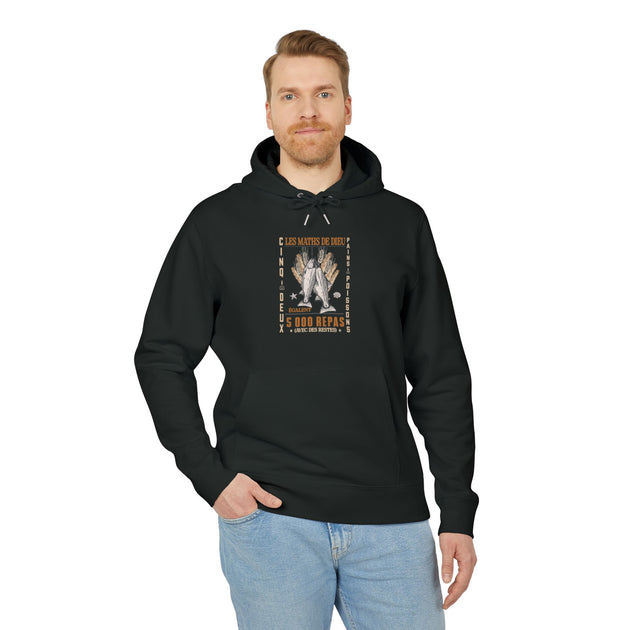 Un homme porte un sweat à capuche noir avec une illustration chrétienne sur la poitrine.