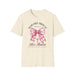 T-shirt beige pour femme orné d'un nœud vichy rose, d'une croix et du verset Romains 5:8.