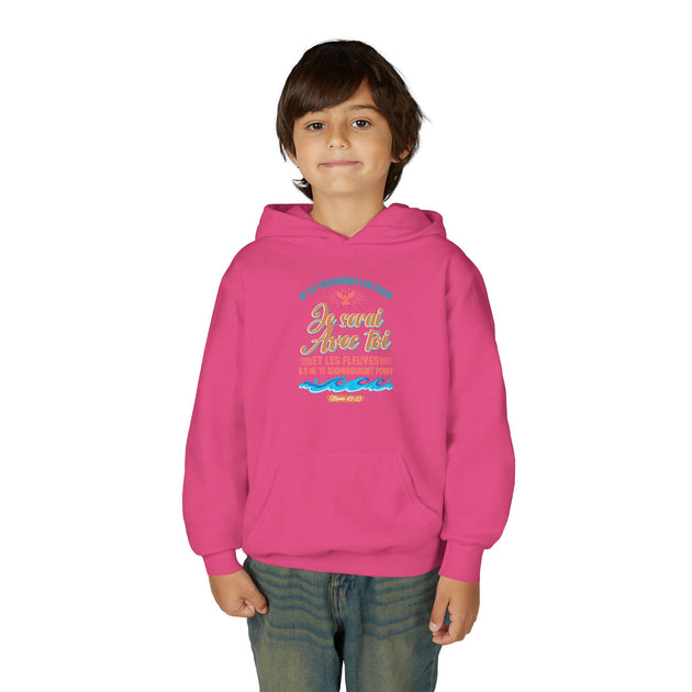 Un enfant porte un sweat à capuche rose avec une inscription religieuse et des vagues sur la poitrine.