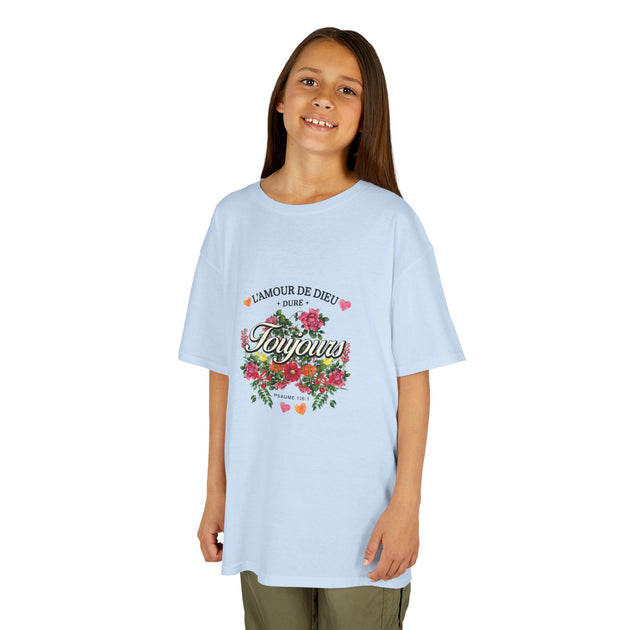 Une jeune fille porte un t-shirt bleu clair orné d'un motif floral et du texte L'Amour de Dieu.