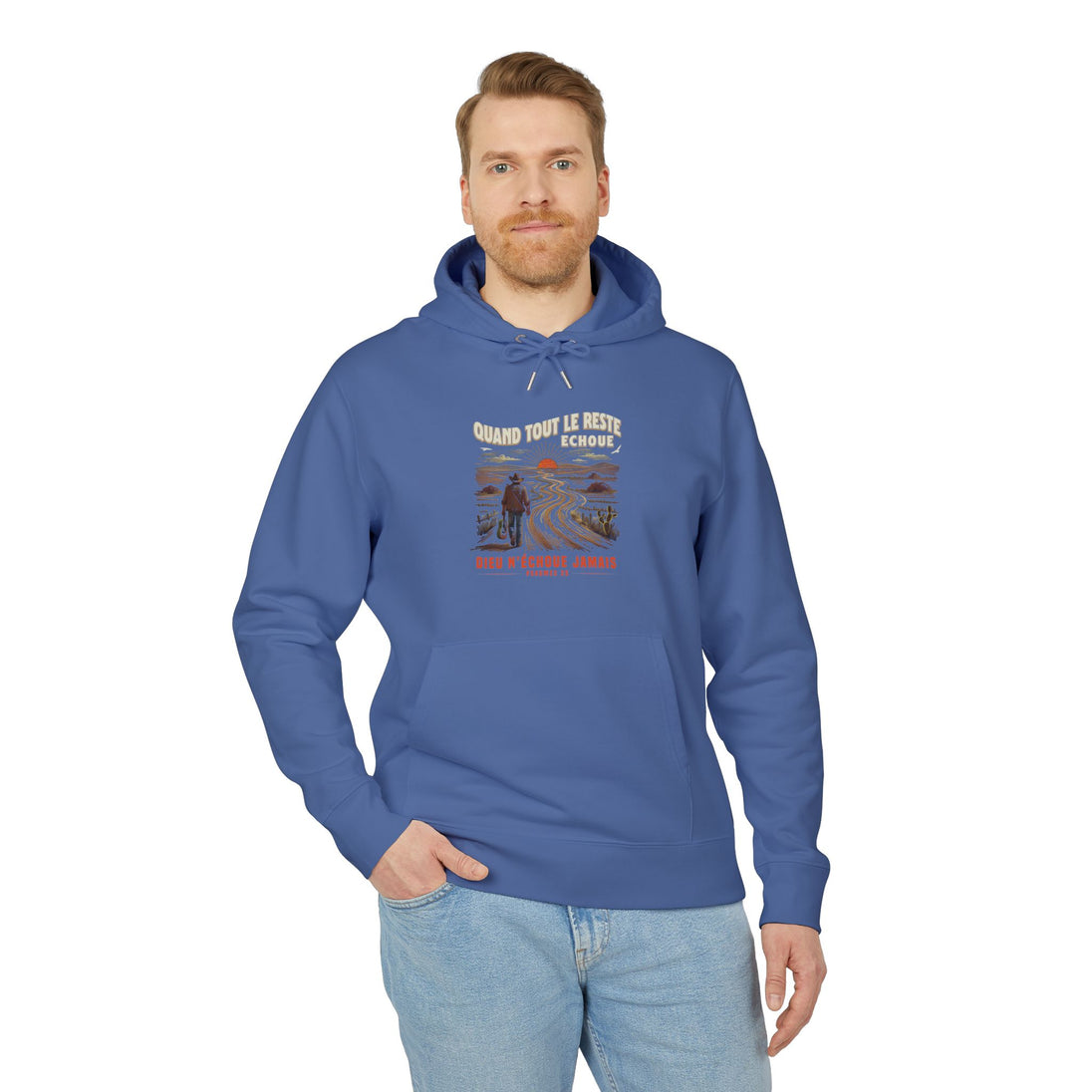 Un homme porte un sweat à capuche bleu avec une illustration de désert et un message religieux.