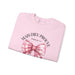 Sweatshirt rose pâle plié avec un nœud vichy et l'inscription Mais Dieu prouve Romains 5:8.