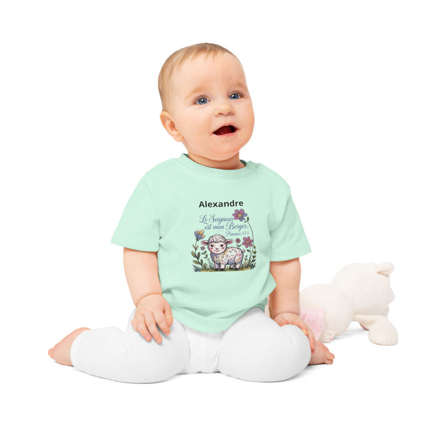 Bébé assis portant un t-shirt vert menthe personnalisé avec un agneau et le texte religieux.