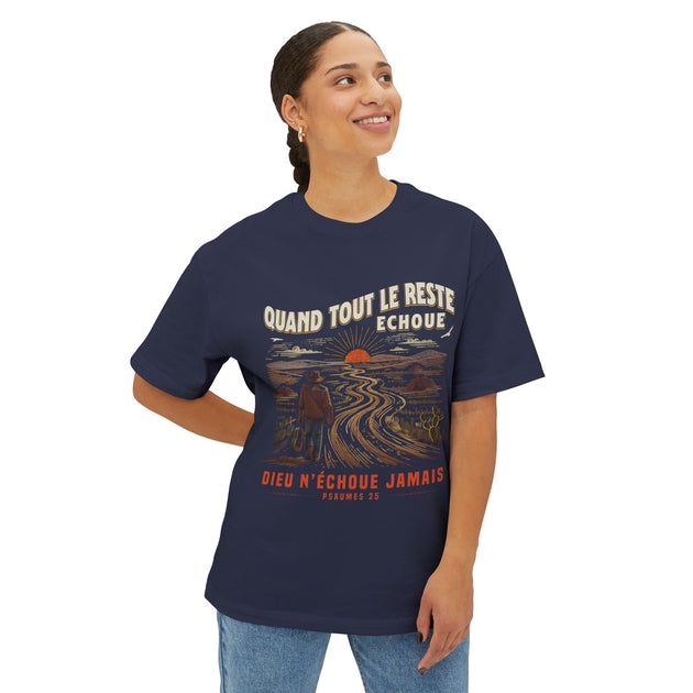 Une femme porte un t-shirt bleu marine avec une illustration de voyageur et un texte religieux.