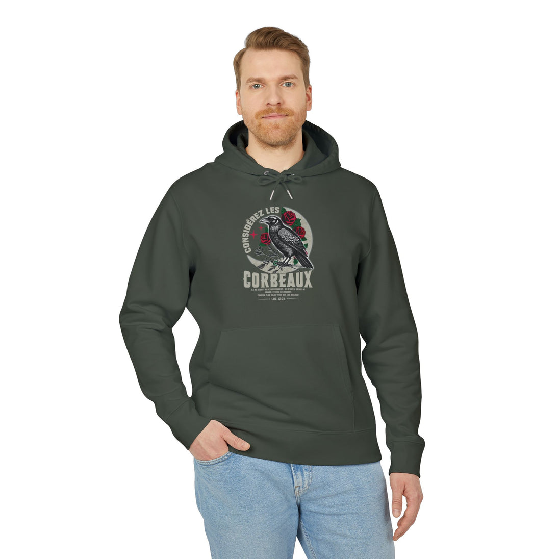 Un homme porte un sweat à capuche vert foncé avec une illustration de corbeau et des roses.