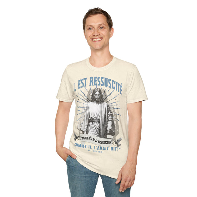 Un homme porte un t-shirt beige illustré de Jésus avec l'inscription Il est ressuscité.