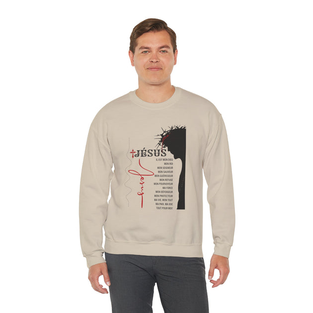 Un homme porte un sweat-shirt beige avec une illustration religieuse et du texte en français.
