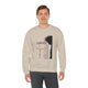 Un homme porte un sweat-shirt beige avec une illustration religieuse et du texte en français.