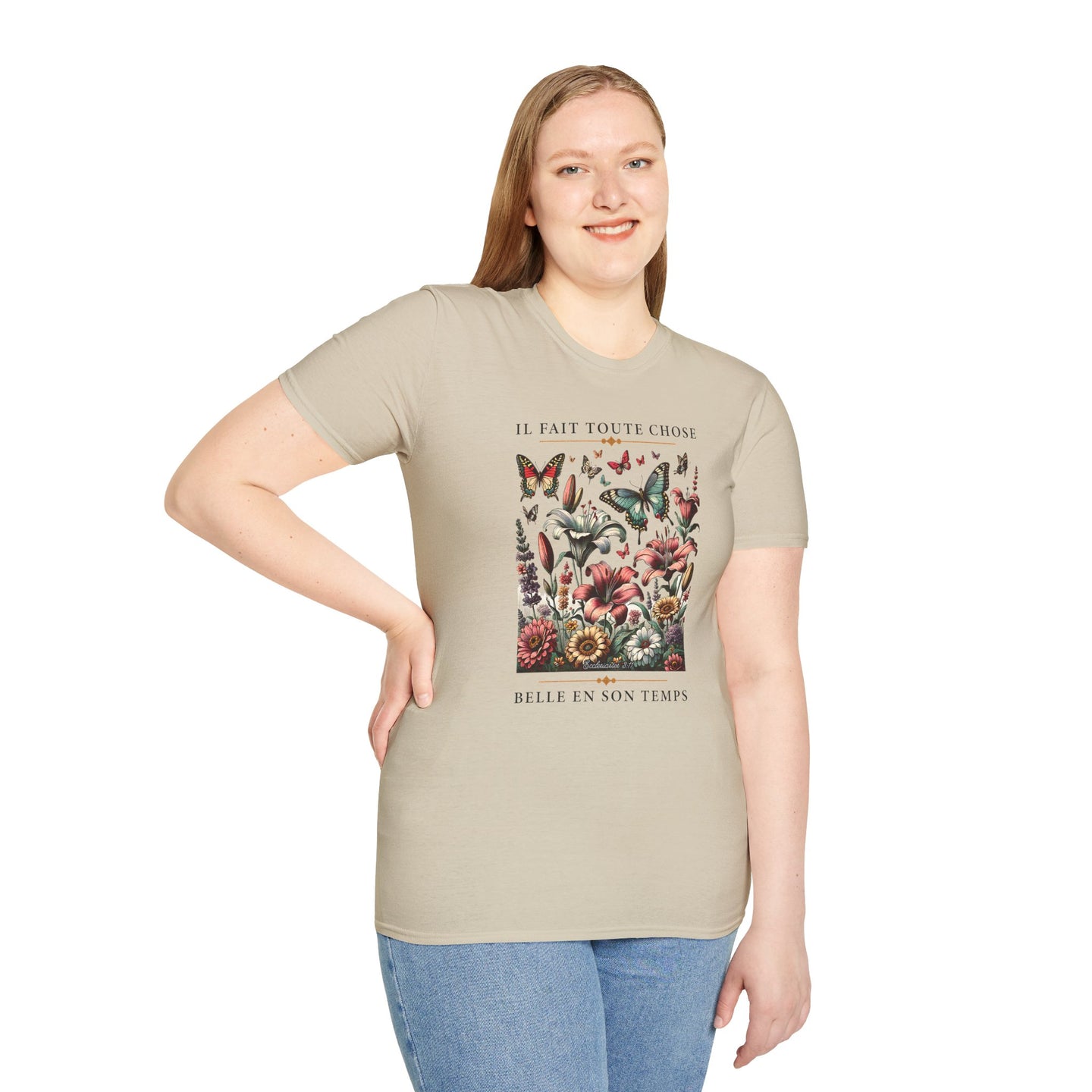 Une femme porte un t-shirt beige orné d'un motif floral et de papillons avec une inscription.