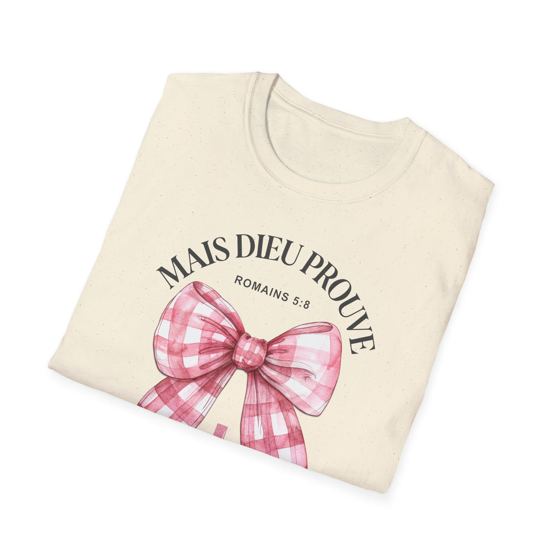 T-shirt beige plié avec un nœud vichy rose et l'inscription Mais Dieu prouve Romains 5:8.