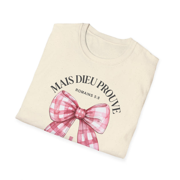 T-shirt beige plié avec un nœud vichy rose et l'inscription Mais Dieu prouve Romains 5:8.