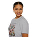 Une femme porte un t-shirt gris orné d'un motif floral et de papillons avec un texte inspirant.