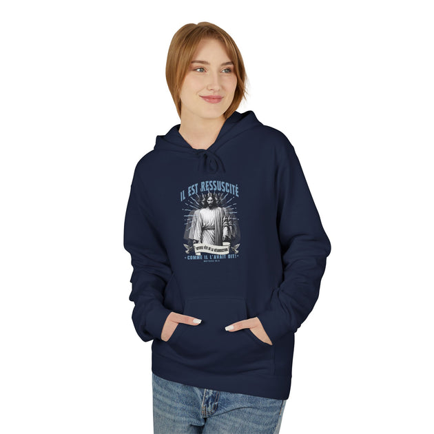 Une femme porte un sweat à capuche bleu marine avec une illustration religieuse sur la poitrine.