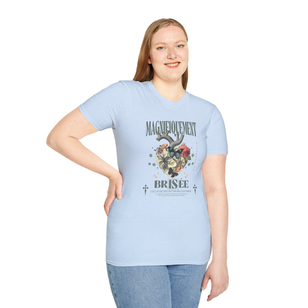 Une femme porte un t-shirt bleu clair avec un motif de cœur floral et un texte religieux.