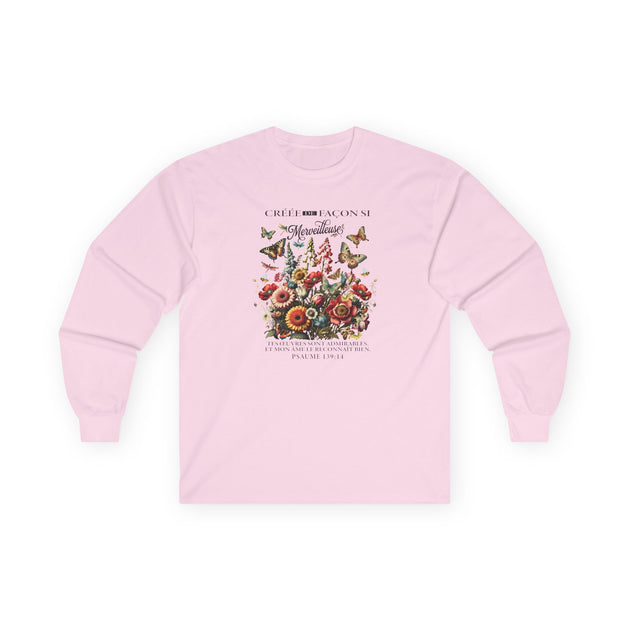 T-shirt rose à manches longues avec un imprimé floral et des papillons sur le devant.