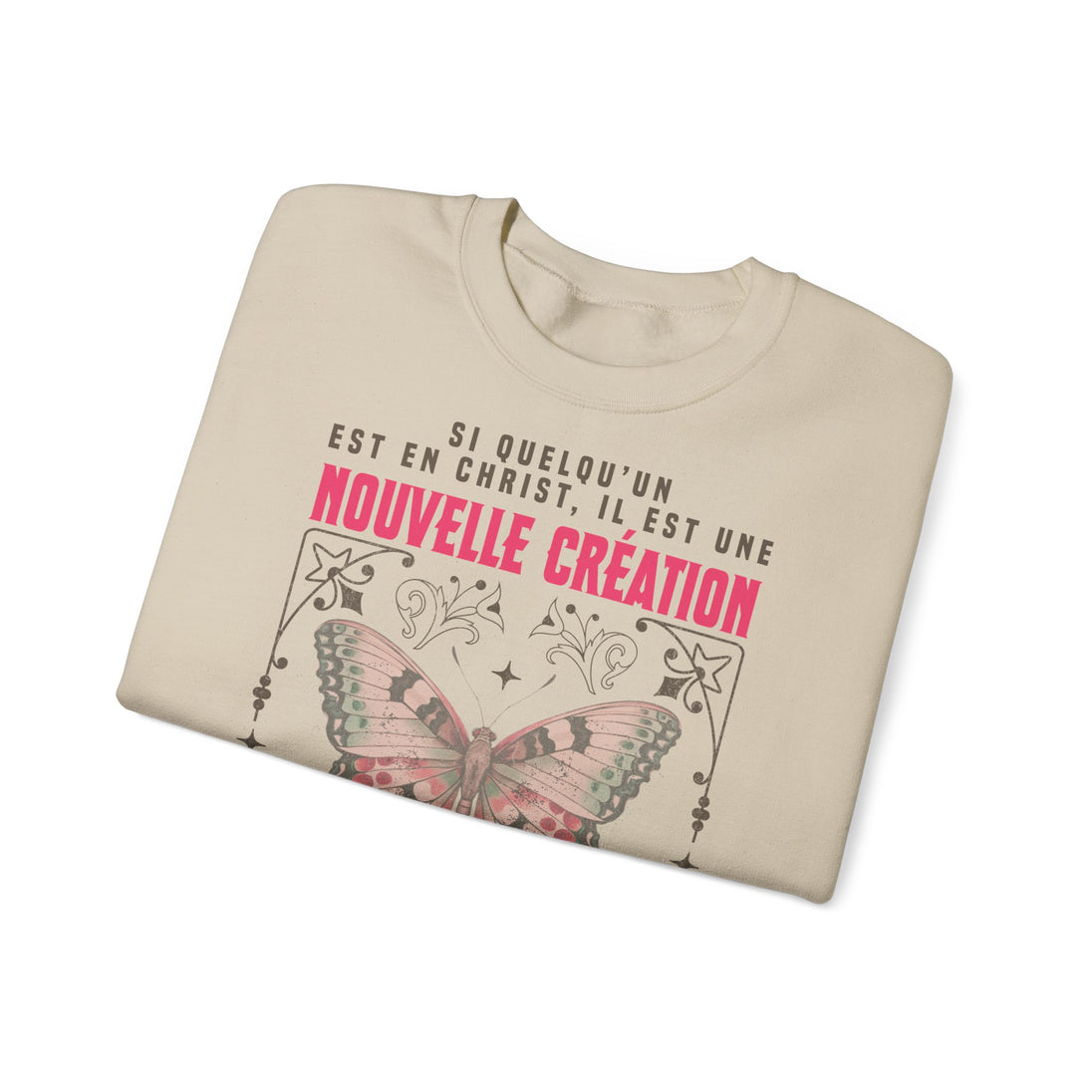 Sweat-shirt beige plié avec un papillon et le texte Si quelqu'un est en Christ, il est une création.