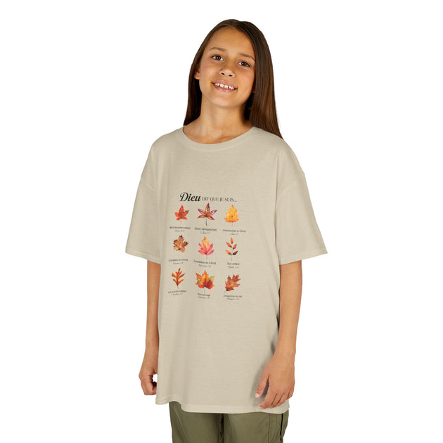 Une jeune fille porte un t-shirt beige orné d'un motif de feuilles et de textes religieux.