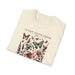 T-shirt beige plié avec une illustration de fleurs et de papillons et le texte Il fait toute chose.