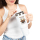 Une femme tient un grand mug de voyage blanc avec une illustration de cerf et un verset biblique.