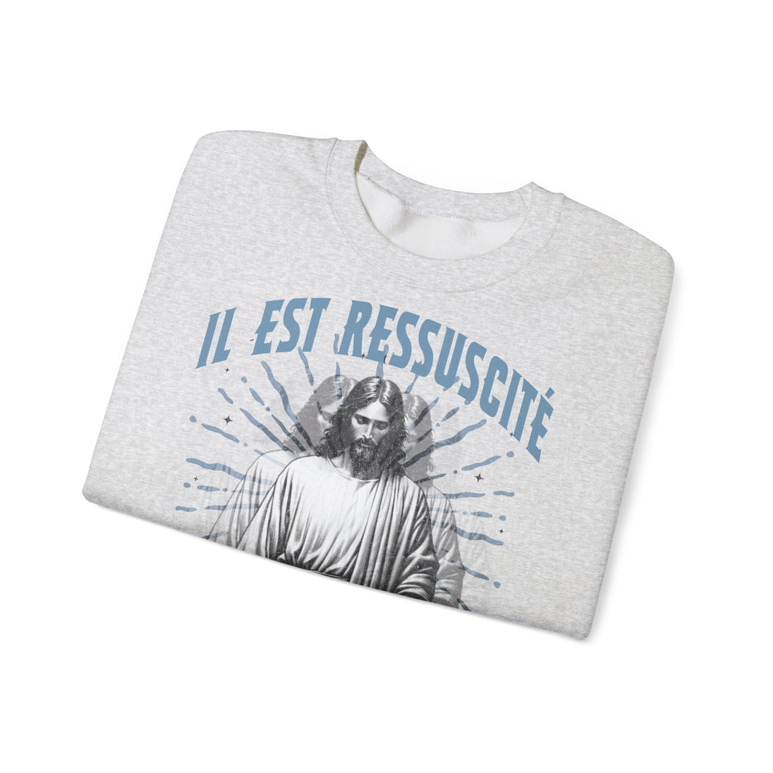 Sweatshirt gris chiné plié avec l'inscription bleue Il est ressuscité et une image de Jésus.