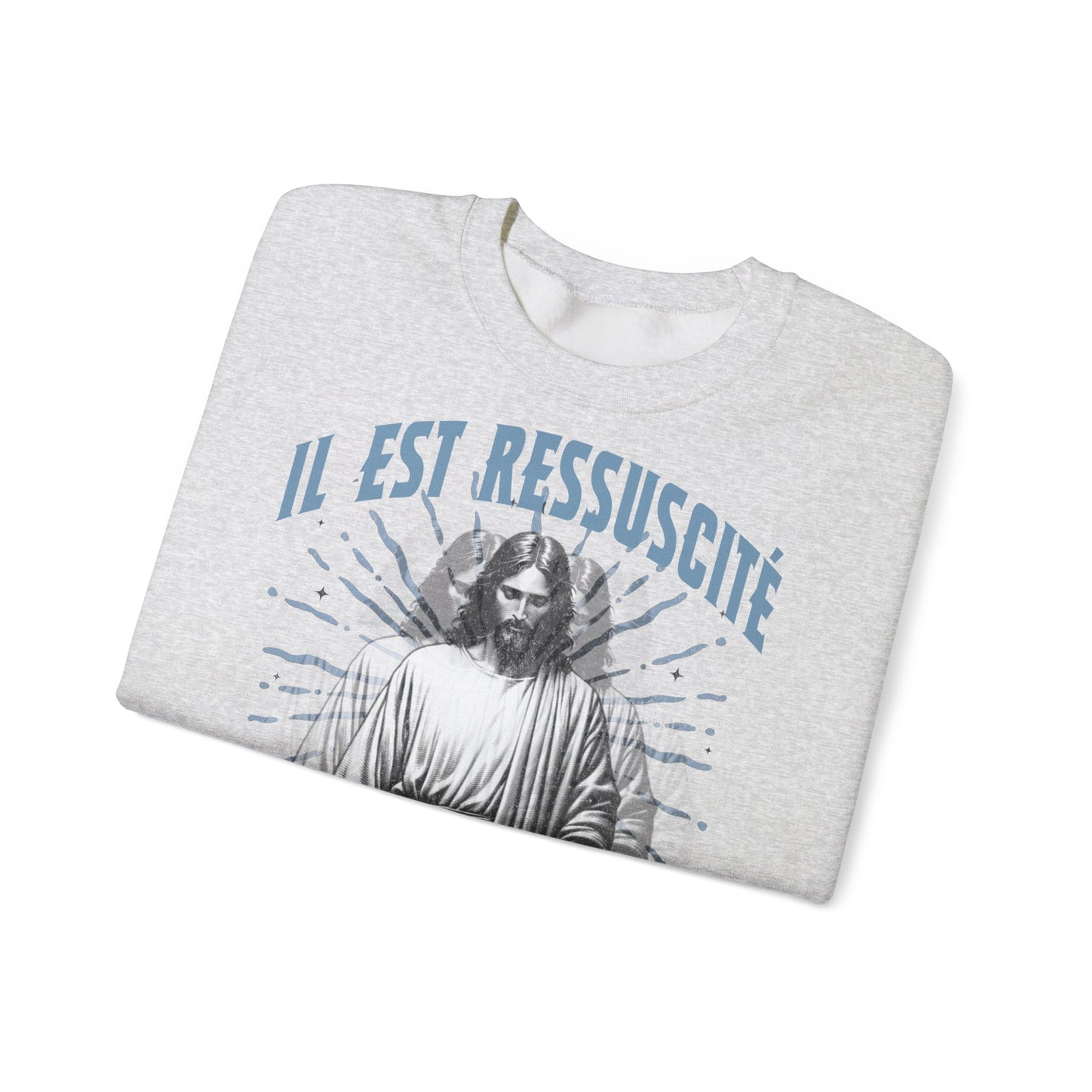 Sweatshirt gris chiné plié avec l'inscription bleue Il est ressuscité et une image de Jésus.