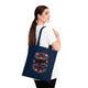 Une femme porte un sac fourre-tout bleu marine orné de l'inscription Dieu est bon en tout temps.