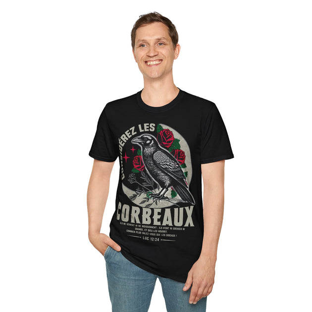 Un homme porte un t-shirt noir illustré d'un corbeau, de roses et d'un verset biblique.