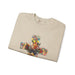 Sweat-shirt beige plié orné d'une croix florale colorée avec une colombe au centre.