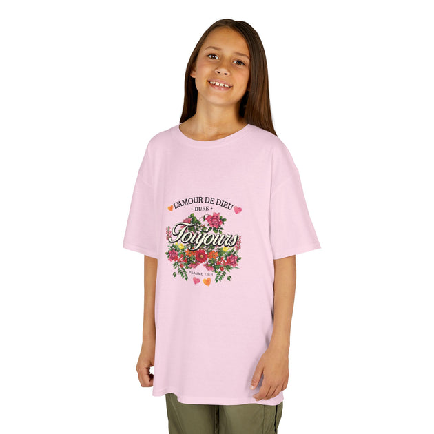 Une jeune fille porte un t-shirt rose orné d'un motif floral et du texte L'Amour de Dieu.