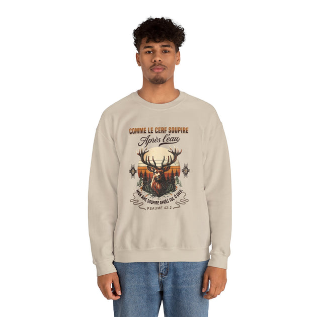 Un homme porte un sweat-shirt beige avec une illustration de cerf et un verset biblique.