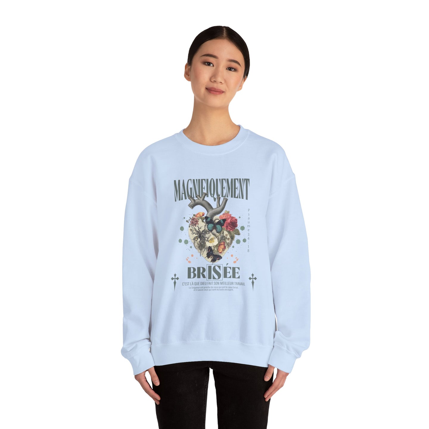 Une femme porte un sweat-shirt blanc orné d'un motif de cœur floral et de texte en français.